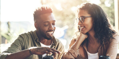A man and a woman sitting next ot each other mirroring their gestures.